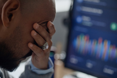 Мужчина анализирует рыночные данные на компьютере в информационном офисе. - SeventyFour