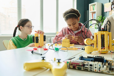 Многонациональные девочки создают проект по робототехнике в классе Stem - SeventyFour