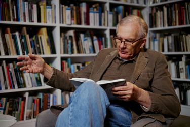 Пожилой мужчина читает книгу дома в рамках кампании по обучению на протяжении всей жизни - DragonImagesAsia