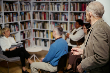 Пожилой мужчина присоединяется к дискуссии Книжного клуба в читательской группе библиотеки - DragonImagesAsia
