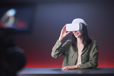 Женщина в VR-гарнитуре для демонстрации технологии погружения - Pressmaster