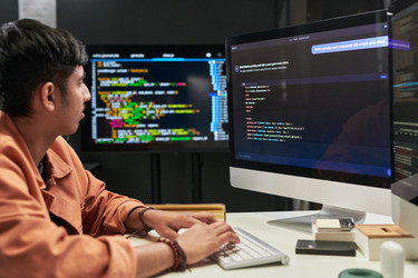 Молодой программист, кодирующий интерфейс искусственного интеллекта для разработки программного обеспечения - Pressmaster