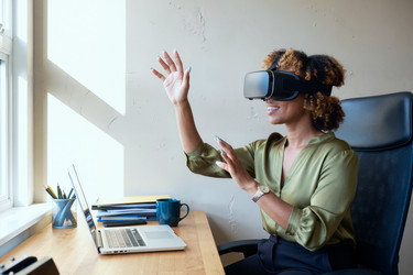 Чернокожая женщина в Vr-гарнитуре работает в современном офисе - Pressmaster