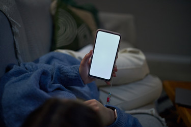 Женщина держит смартфон с пустым экраном для макета приложения - SeventyFour