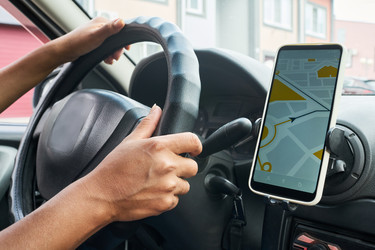 Женские руки управляют автомобилем с помощью GPS-навигационной карты смартфона - Pressmaster
