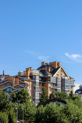 Modern low-rise residential building with a stylish facade under a bright blue sky. / Современный малоэтажный жилой дом со стильным фасадом под ярким голубым небом - kitikat
