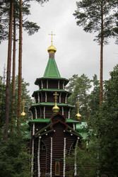 Beautiful wooden Orthodox church with a green roof and golden domes in a pine forest. / Красивый деревянный православный храм с зеленой крышей и золотыми куполами в сосновом бору - kitikat