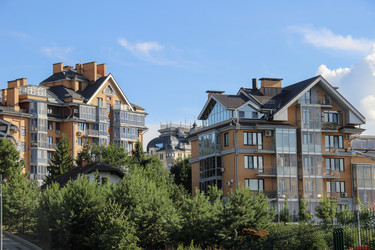 Contemporary townhouses with glass balconies behind green trees and bushes. / Современные таунхаусы со стеклянными балконами за зелеными деревьями и кустами - kitikat