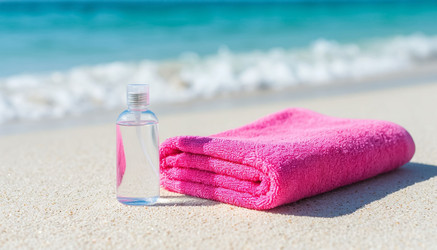 Pink towel and shower gel on white sand — the ultimate beach aesthetic. Fresh, summery, and stylish self-care in one shot - Nik.Alex