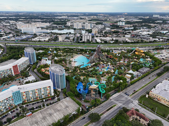 Вид с высоты птичьего полета на аквапарк Volcano Bay с вулканом, бассейнами, горками и близлежащим движением на шоссе в Орландо, Флорида, США. g - EOS_Canon