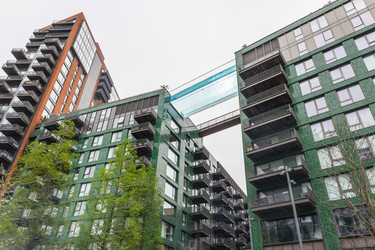 Вид под низким углом на современные жилые здания с прозрачным мостом sky pool bridge в Лондоне - Tartezy