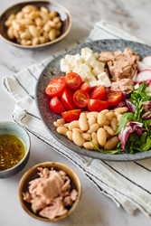 Полезный салат из тунца с белой фасолью, сыром фета, помидорами, редисом и зеленью на мраморном столе - Irrin0215