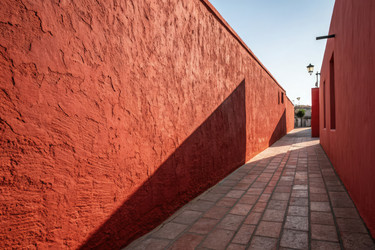 Oblique View of Vivid Red Stucco Wall Along a Narrow Path Generative AI - RomanZ
