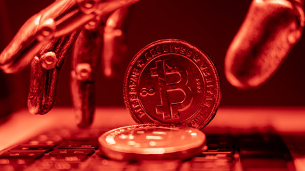 Криптовалюта Биткоин на клавиатуре ноутбука красного цвета. Концепция цифровых валют, мир компьютерных технологий, безналичные платежи в криптовалютах. Роботизированная рука берет биткойн-монету - AntonSAN