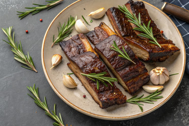 Копченые говяжьи ребрышки, украшенные розмарином и зубчиками чеснока Generative AI - RomanZ