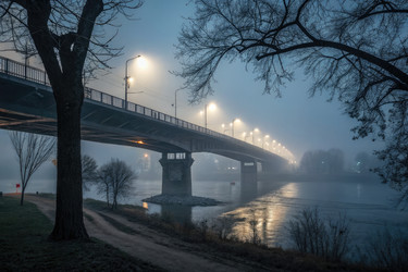 Туманный вечер на берегу реки с освещенным мостом на заднем плане - RomanZ
