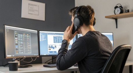 Мужчина, работающий в домашнем офисе с несколькими мониторами - Vvicca