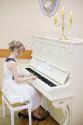 Beautiful girl in white dress plays white piano in light room - paha_l