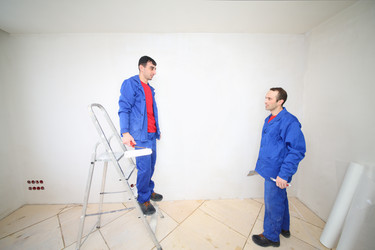 Two workers in blue clothes on ladder stand with - paha_l