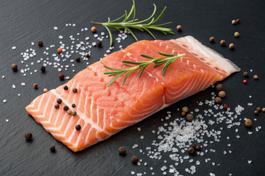 свежее филе лосося, украшенное зеленью и специями на темном фоне - RomanZ