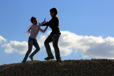 Brother and sister fun pushing each other from the hill - paha_l
