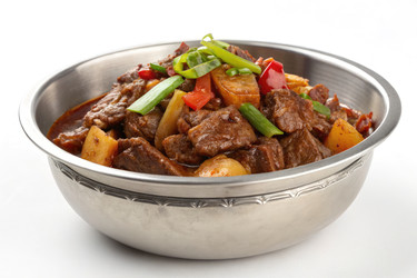 вкусное тушеное мясо из говядины подается в серебряной миске со свежими овощами - RomanZ