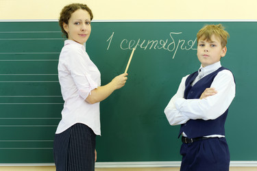 Мальчик и учительница стоят возле зеленой классной доски с надписью - paha_l