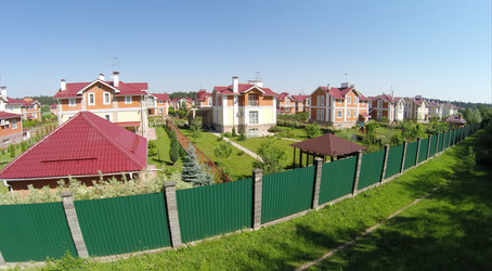 Вид с высоты птичьего полета на коттеджный городок рядом с лесом в солнечный летний день - paha_l