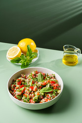 Салат табуле с булгуром, помидорами и огурцами на зеленом фоне - JuliaLavleis