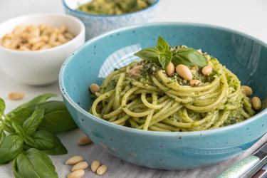 вкусные спагетти с соусом песто и кедровыми орешками подаются в голубой миске - RomanZ