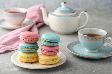 Красочные macarons и чайным набором, расположенных на стол для послеобеденного удовольствия - RomanZ