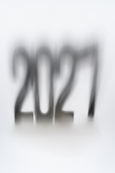 Абстрактный вертикальный фон крупным планом концепции предстоящего 2027 года. Мягкие темные тени накладывают силуэт типографских цифр на чистую белую поверхность бумаги с креативной текстурой размытия и большим пространством для копирования - IKvyatkovskaya