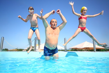 дедушка с мальчиком и девочкой прыгают в бассейн с водой - paha_l