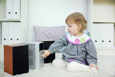 Little cute girl presses button on music system in room at - paha_l