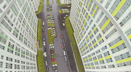 автомобили на парковке в дождливый день среди жилых зданий - paha_l