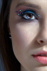 Снимок лица человеческой женщины крупным планом. женщина с красивым макияжем лица и глаз с синими тенями для век и стразами - Serg Zastavkin