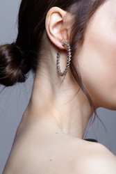 Bunette female side view with hair knot and earring in the ear on grеy background - Serg Zastavkin