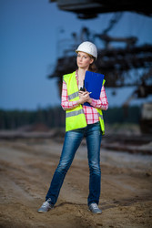 Female worker standing with folder on sand on backgroud of - paha_l