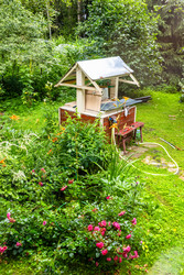 Новый деревянный колодец на зеленом заднем дворе в деревне - vale