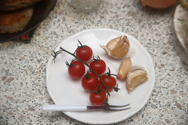 Вкусные красные помидоры черри с чесноком и сметаной на столе, крупный план - ZemLenik_photoclb