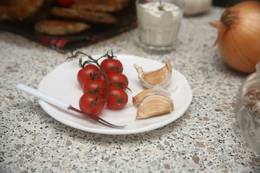 Вкусные красные помидоры черри с чесноком и сметаной на столе, крупный план - ZemLenik_photoclb