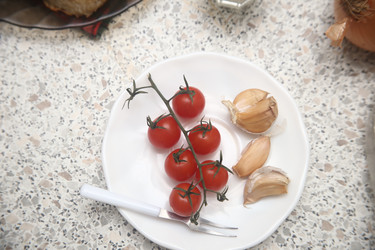 Вкусные красные помидоры черри с чесноком и сметаной на столе, крупный план - ZemLenik_photoclb