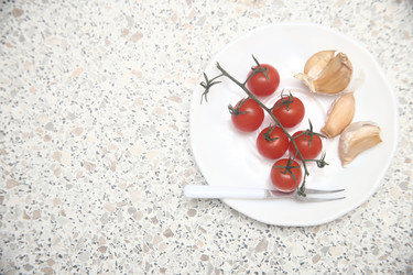 Вкусные красные помидоры черри с чесноком и сметаной на столе, крупный план - ZemLenik_photoclb