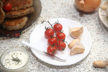 Вкусные красные помидоры черри с чесноком и сметаной на столе, крупный план - ZemLenik_photoclb
