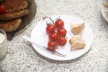 Вкусные красные помидоры черри с чесноком и сметаной на столе, крупный план - ZemLenik_photoclb