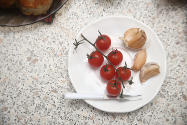 Вкусные красные помидоры черри с чесноком и сметаной на столе, крупный план, вид сверху - ZemLenik_photoclb