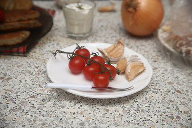 Вкусные красные помидоры черри с чесноком и сметаной на столе, крупный план - ZemLenik_photoclb