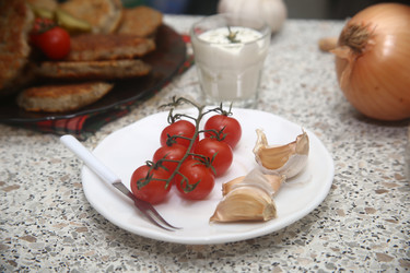 Вкусные красные помидоры черри с чесноком и сметаной на столе, крупный план - ZemLenik_photoclb
