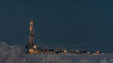 освещенная буровая установка для добычи нефти и газа, работающая в суровых снежных условиях арктики во время зимней полярной ночи. концепция промышленной добычи и разведки энергии - Vkadimir