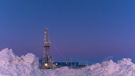 зимний вид работающей буровой установки для добычи нефти и газа, покрытой снегом, в суровых арктических условиях во время полярных сумерек. прекрасное пурпурное небо - Vkadimir